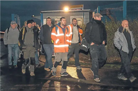  ?? Picture: Tina Norris. ?? Uncertain future: grim-faced BiFab workers emerge from the Burntislan­d yard after finishing their shifts last night.