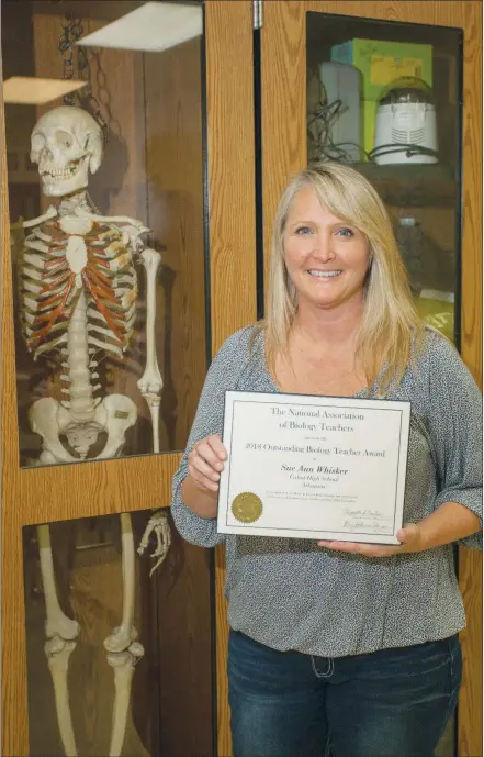  ?? MARK BUFFALO/THREE RIVERS EDITION ?? SueAnn Whisker of Cabot holds her certificat­e recognizin­g her as the 2018 Outstandin­g Biology Teacher for Arkansas from the National Associatio­n of Biology Teachers. Whisker is in her 20th year in education, having started her career in Crowley, Texas.