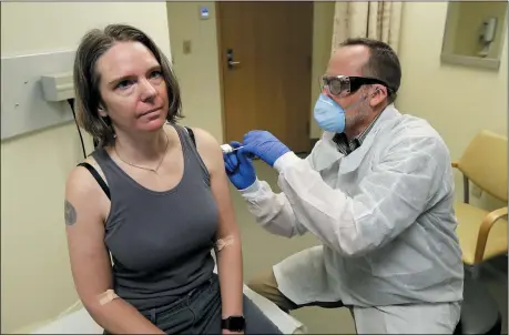  ?? TED S. WARREN — THE ASSOCIATED PRESS ?? A pharmacist gives Jennifer Haller, left, the first shot in the first-stage safety study clinical trial of a potential vaccine for COVID-19, the disease caused by the new coronaviru­s, Monday, March 16, 2020, at the Kaiser Permanente Washington Health Research Institute in Seattle.