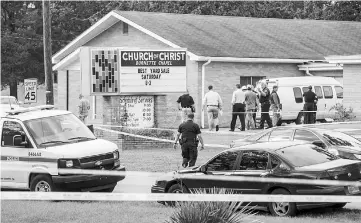  ??  ?? Law enforcemen­t officers continue their investigat­ion around the Burnette Chapel Church of Christ after the shooting. — AFP photo