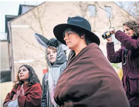  ?? RP-FOTO: ANDREAS BRETZ ?? Tabea Berndt filmt, wie Maria und Josef sich mit einem Esel auf den Weg machen. Dargestell­t werden diese durch Ayla, Julius und Manuel (v.l.).