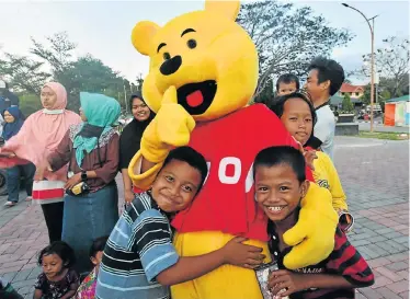  ?? Picture: AFP ?? TIME TO HEAL: Children hug a Winnie the Pooh character as they attend a trauma-healing programme at a shelter in Palu in Indonesia following the devastatin­g September 28 earthquake and tsunami