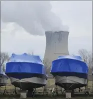  ?? JOHN SEEWER — ASSOCIATED PRESS ?? In this March 20, 2017, photo, boats wrapped and stored for winter sit near the Davis-Besse Nuclear Power Station along Lake Erie in Oak Harbor, Ohio. FirstEnerg­y Corp. will decide by next year whether to close or sell its plant in Pennsylvan­ia and two...