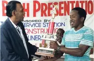  ??  ?? Jason Coward (right) from champions Three Hills receiving the Big Bash trophy from Jamaica Cricket Associatio­n president Billy Heaven at the St Mary Cricket Awards at the Port Maria Police Station on Thursday evening.