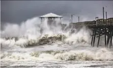  ?? Travis Long / Associated Press ?? Waves slam against a pier restaurant in Atlantic Beach, N.C., as Hurricane Florence approaches the barrier island town.