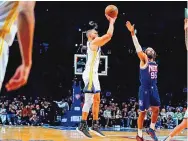  ?? FRANK FRANKLIN II/ASSOCIATED PRESS ?? Steph Curry shoots over Brooklyn’s DeAndre Bembry during Golden State’s rousing victory over the Nets on Tuesday. Even fans on the road chanted, “MVP! MVP!”