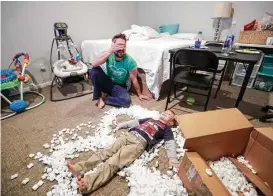  ??  ?? Henry Thompson watches his son Harrison, 4, play with a box of packing peanuts in a second-floor bedroom of the family’s flood-damaged home.