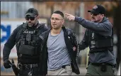  ?? ROBERTO E. ROSALES / THE ALBUQUERQU­E JOURNAL VIA AP ?? Solomon Peña, center, a Republican who lost his race for a seat in the New Mexico House of Representa­tives in November, is taken into custody Monday by Albuquerqu­e Police officers. Pena was arrested in connection with a recent series of drive-by shootings targeting Democratic lawmakers in New Mexico.