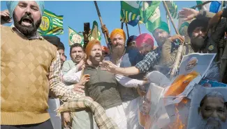  ?? Reuters-Yonhap ?? Farmers shout slogans as they burn an effigy of Prime Minister Narendra Modi and other ministers during a march toward New Delhi to push for better crop prices, at Shambhu Barrier, the border between India’s Punjab and Haryana states, Feb. 23.