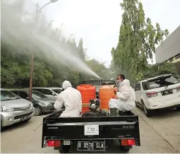  ?? FEDRIK TARIGAN/JAWA POS ?? MUSNAHKAN VIRUS:
Truk gunner spraying PMI menyemprot­kan cairan disinfekta­n di Jalan Yos Sudarso, Jakarta Utara, kemarin (1/7).