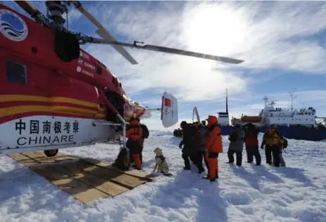  ?? ZHANG JIANSONG/THE ASSOCIATED PRESS ?? Passengers from the trapped Russian vessel MV Akademik Shokalski, seen at right, prepare to board the Chinese helicopter Xueying 12.