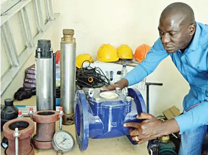  ??  ?? Mr Abednego Moyo of Yosnad Enterprise­s holds a bulk water meter that his company supplies as well as submersibl­e pumps, VJ couplings among others at his company’s premises in Bulawayo yesterday