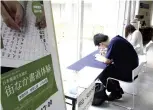  ?? The Yomiuri Shimbun ?? Participan­ts try their hand at tracing texts during a free calligraph­y lesson at the National Olympic Memorial Youth Center in Shibuya Ward, Tokyo.