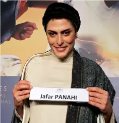  ?? — Reuters photo ?? Cast member Behnaz Jafari holds a card with the name of the director Jafar Panahi during a news conference at the 71st Cannes Film Festival in Cannes.