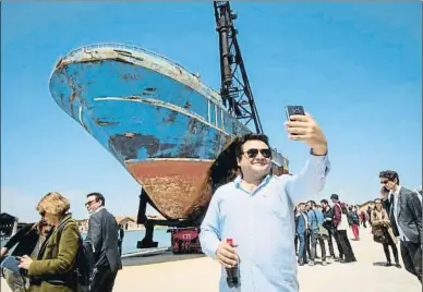  ?? . ?? Selfies y copas frente a un símbolo de la muerte en el mar
Convertido en obra de arte por el suizoislan­dés Christoph Büchel, que la titula Barca Nostra, el pesquero egipcio ha suscitado polémica en la Bienal de Venecia. Se montan meriendas a su vera, y los transeúnte­s lo ven como atracción y motivo de selfie