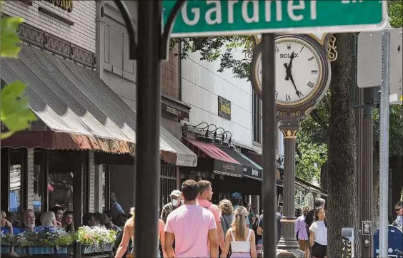  ?? Photos by Will Waldron / Times Union ?? Broadway bustles with activity during lunchtime in Saratoga Springs as throngs of summer vacationer­s visit the historic Spa City.