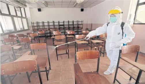  ?? CHANAT KATANYU ?? A classroom is sprayed with disinfecta­nt at Samsenwitt­ayalai School in Bangkok. The school closed yesterday after its board learned that a Mathayom 2 student and his family stayed at the hotel in Rayong where a visiting Egyptian soldier who later tested positive for Covid-19 was staying.