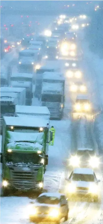  ??  ?? the motorway. Above: HGVs grind to a halt on the snowy M80 near Haggs