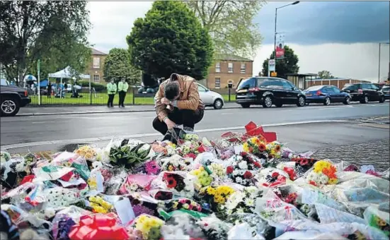  ?? DAN KITWOOD / GETTY IMAGES ?? Los vecinos dejaron flores donde el miércoles fue asesinado por musulmanes radicaliza­dos un soldado, cerca de los barracones de Woolwich