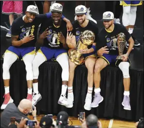  ?? Associated Press ?? Golden State Warriors players pose for photos with the Larry O’Brien Trophy after defeating the Boston Celtics in Game 6 of basketball’s NBA Finals on Thursday in Boston.