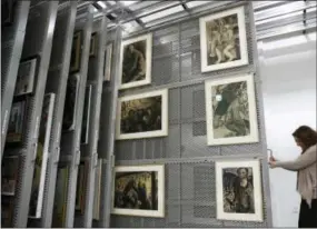  ?? CAROLYN KASTER — THE ASSOCIATED PRESS ?? Laura Seylar, registrar of Collection­s Management, slides open a section of the art rack at the U.S. Holocaust Memorial Museum’s David and Fela Shapell Family Collection­s, Conservati­on and Research Center in Bowie, Md., Monday. The art racks holds...