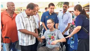  ??  ?? Helping hand: Kulasegara­n having a chat with one of the wheelchair recipients in Kampung Tawas near Ipoh.