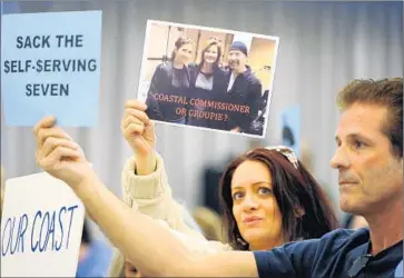  ?? Michael Owen Baker For The Times ?? VENICE RESIDENT Ilana Marosi, with fellow resident Kevin Keresey, holds a photo of coastal commission­er Wendy Mitchell, center, standing beside U2 guitarist David “The Edge” Evans at a hearing in March.
