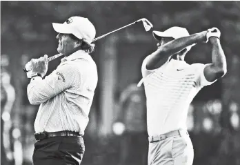  ?? AP Photo/Charlie Riedel ?? PRACTICE. Phil Mickelson, left, and Tiger Woods warm up on the driving range during practice for the Masters golf tournament at Augusta National Golf Club, Tuesday, April 3, 2018, in Augusta, Ga.