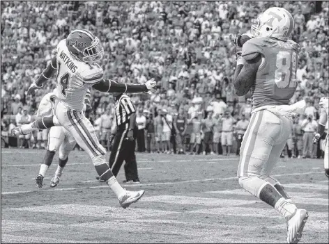  ?? PHOTOS BY WADE PAYNE / ASSOCIATED PRESS ?? Tennessee tight end Mychal Rivera catches a pass for a touchdown as Florida defensive back Jaylen Watkins defends during the second quarter Saturday in Knoxville.