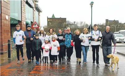  ?? Picture: Dougie Nicolson. ?? Euan, wearing blue jacket and baseball cap, with friends and staff from Morrisons as they head off from the supermarke­t in Arbroath on their sponsored walk to Easthaven and back to raise money for CLIC Sargent.