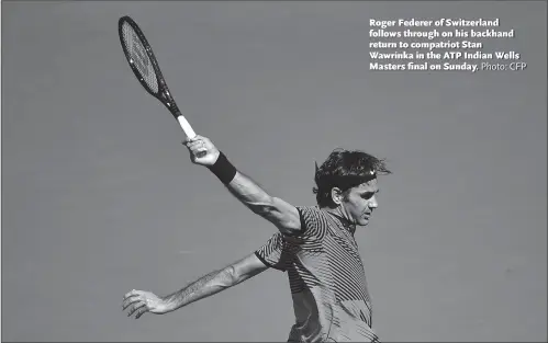  ?? Photo: CFP ?? Roger Federer of Switzerlan­d follows through on his backhand return to compatriot Stan Wawrinka in the ATP Indian Wells Masters final on Sunday.