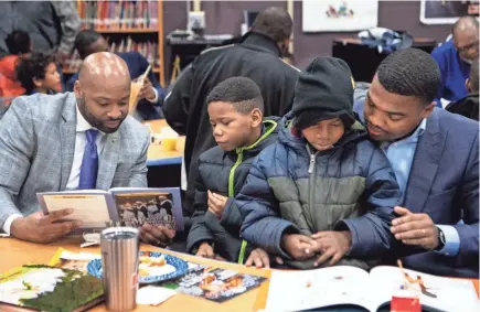  ?? COURTNEY PEDROZA / THE TENNESSEAN ?? Xavier Purdy, from left, Tyrell Kirkwood, Tykese Kirkwood-Welch and Dameion Cowans read together during Fatherhood Fridays at Buena Vista Elementary School in Nashville, Tennessee.