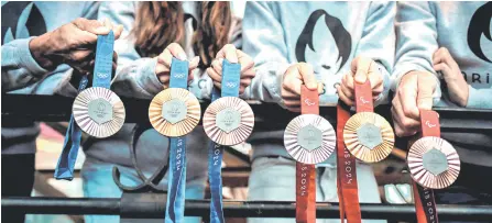  ?? — AFP photo ?? Photo shows the Paris 2024 Olympics (left) and Paralympic­s (right) medals designed by French luxury jewellery house Chaumet during their presentati­on at the Eiffel tower in Paris.