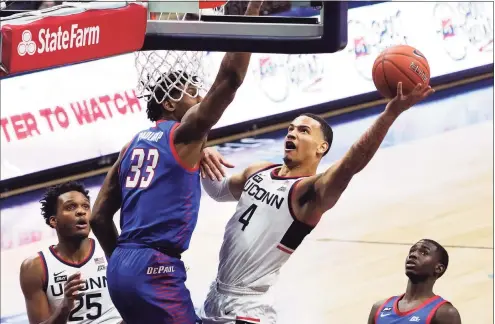  ?? David Butler II / Associated Press ?? UConn guard Tyrese Martin shoots against DePaul forward Pauly Paulicap during Wednesday’s game. Martin, a transfer from Rhode Island, contribute­d 22 points and 10 rebounds.