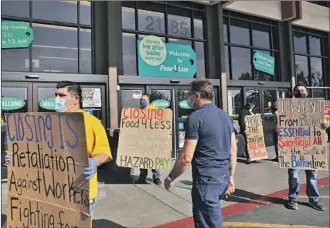  ?? Christina House Los Angeles Times ?? FOOD 4 LESS workers rally outside the Long Beach store to protest the parent company’s move to close two locations because of the city’s hazard-pay ordinance to temporaril­y boost workers’ wages.