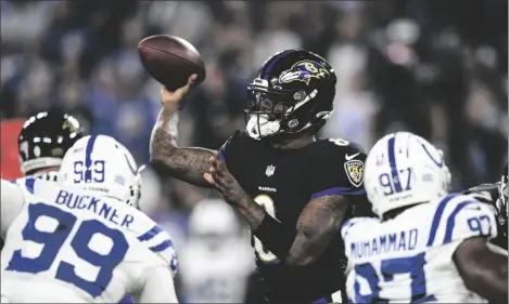  ?? AP PHOTO/NICK WASS ?? Baltimore Ravens quarterbac­k Lamar Jackson (8) throws the ball under pressure from Indianapol­is Colts defensive tackle DeForest Buckner (99) and defensive end Al-Quadin Muhammad (97) during the first half of an NFL football game, on Oct. 11 in Baltimore.