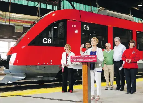  ?? PHOTOS: PATRICK DOYLE/THE CANADIAN PRESS ?? Ontario Liberal Leader Kathleen Wynne speaks in front of the O-Train at the Walkley Yard train maintenanc­e facility, where she outlined her party’s public transit policy.