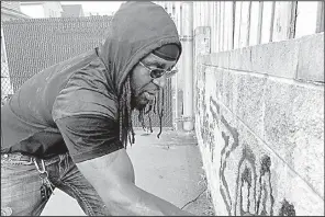  ?? AP/JULIET LINDERMAN ?? Activist Tyree Colion earlier this week spray paints “No Shoot Zone” on a wall behind a convenienc­e store near the spot where a 13-year-old girl was fatally shot in Baltimore County, Md. Police arrested him for destructio­n of private property.