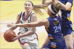  ?? Jessica Hill / Associated Press ?? Uconn's Paige Bueckers drives vs. Marquette's Selena Lott, a Columbia High grad, in the Big East tourney final on Monday.