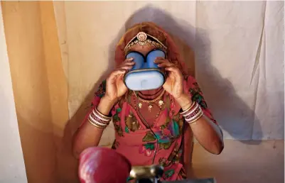  ??  ?? + EYE ON YOU: A villager performs an iris scan at an Aadhaar enrollment center in Rajasthan, India, in February 2013.