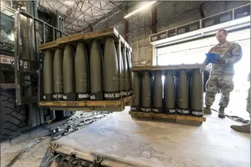  ?? AP file photo ?? U.S. Air Force Staff Sgt. Cody Brown (right), with the 436th Aerial Port Squadron, checks pallets of 155 mm shells ultimately bound for Ukraine, April 29, at Dover Air Force Base, Del. The U.S. is sending another $400 million to Ukraine, pushing needed ammunition and generators to Ukraine from its own stockpiles, which will allow the aid to get to Ukraine faster than if the Pentagon procured the weapons from industry., getting needed heat and additional air defenses to Kyiv as winter sets in.