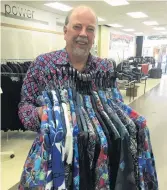  ??  ?? Alex Campbell Menswear owner Lindsay Campbell holds a selection of stylish summer shirts now in stock.