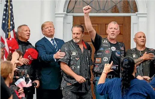  ?? AP ?? President Donald Trump stands in the rain with members of Bikers for Trump and supported after saying the Pledge of Allegiance.