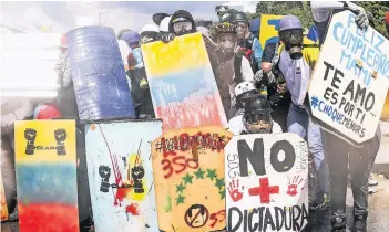  ?? FOTO: DPA ?? Die Proteste gegen den venezolani­schen Präsidente­n Nicolás Maduro gehen unverminde­rt weiter. Opposition­elle schützen sich bei einer Demonstrat­ion in Caracas vor der Polizei.