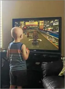  ?? KATHLEEN CAREY — DIGITAL FIRST MEDIA ?? Four-year-old Benjamin Austin enjoys one of his favorite pastimes - playing Mario Kart - inside the new HEADStrong facility in Ridley.