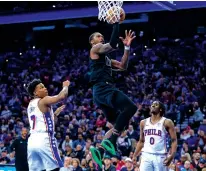  ?? CHRIS SZAGOLA/THE ASSOCIATED PRESS ?? The Brooklyn Nets’ Lonnie Walker IV, center, goes up to shoot as the Philadelph­ia 76ers’ Kyle Lowry, left, and Tyrese Maxey watch during the first half of Sunday’s game in Philadelph­ia.