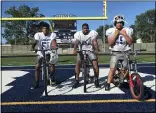  ?? MICHAEL FITZPATRIC­K — THE MORNING JOURNAL ?? Robert Brown, left, Joseph Davis-Hill and Tyrone Jackson are three freshman football players at Lorain High who were gifted rehabbed bikes by the Lorain Police Department.