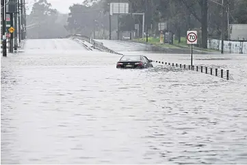  ?? ?? ALERT: A car abandoned in floodwater on the outskirts of Sydney.