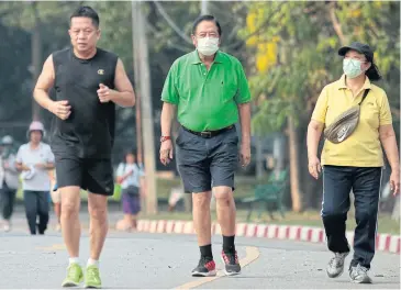  ??  ?? People wear face masks while exercising in Lumpini Park in Pathumwan district of the capital. Air pollution in the capital has been far above the so-called safe limits for two consecutiv­e weeks. The public has been advised to avoid exercising outdoors.