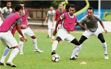  ??  ?? Holding on to the ball: Shafiq Shaharuddi­n (second from right) and national teammates during a training session at Wisma FAM yesterday.